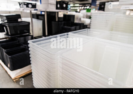 Les contenants en plastique transparent et noir pile dans un magasin Banque D'Images