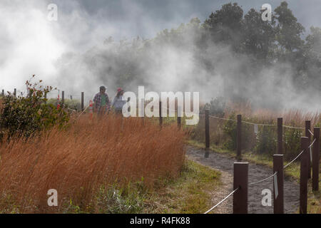 Hawaii Volcanoes National Park, New York - Les Randonneurs sur un sentier au bord de l'Kilauea volcano. La vapeur provient de la vapeur du volcan d'air. Banque D'Images