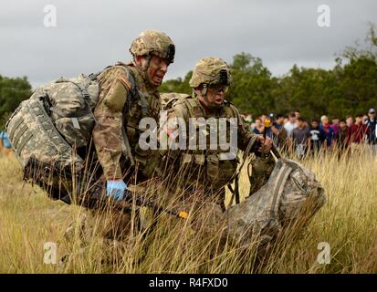 1LT. Michael Kehoe et le Sgt. 1re classe Ismael Rodriguez, représentant de la 30e brigade médicale, faites glisser un patient simulé sur un espace zone de danger au cours de l'US Army's Best Concours Infirmier au Camp Bullis, Texas, le 25 octobre 2016. Les étudiants d'une école secondaire locale San Antonio comme spectated les concurrents ont commencé leur première journée officielle de la compétition. Banque D'Images