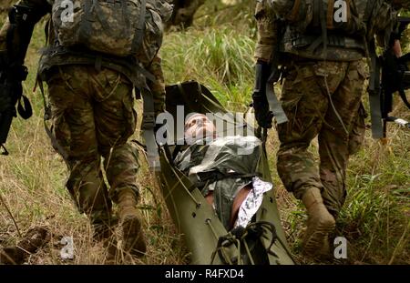 Le Sgt. Edwin Luchendo et le Sgt. Nicholas Santos, représentant la Division de cavalerie, faites glisser leur victime simulée à travers le bois ligne lors de l'US Army's Best Concours Infirmier au Camp Bullis, Texas, le 25 octobre 2016. Banque D'Images