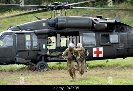 Le Sgt. Edwin Luchendo et le Sgt. Nicholas Santos, représentant la Division de cavalerie, effectuer une distance de sécurité de l'UH-60 Blackhawk après avoir chargé un blessé pendant l'armée américaine meilleur concours Infirmier au Camp Bullis, Texas, le 25 octobre 2016. Banque D'Images