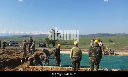 Les marins de la Construction Navale du Bataillon mobile 1 Travailler avec les soldats de la 10e Brigade Ingénieur roumain de la construction d'un bâtiment de stockage et d'opérations dans le cadre de Resolute Château 17 au Centre national de formation conjointe, Cincu, Roumanie. Les Seabees sont établissant une barrière de vapeur et d'armature avant de placer la dalle de béton. Château ferme 17 est un exercice le renforcement de l'alliance de l'OTAN et de renforcer sa capacité de formation conjointe et de réponse aux menaces dans la région. Banque D'Images