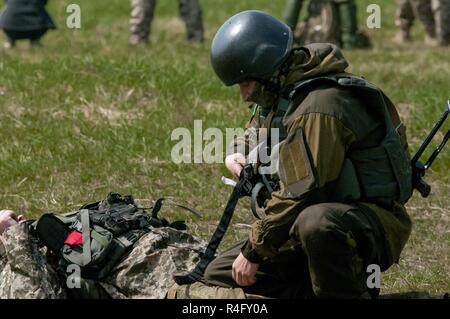 Un soldat du 1er Bataillon aéromobile, 79e Brigade d'assaut aérien applique un garrot pendant le combat sauvé la vie lors de la formation sur la CCT de Yavoriv de maintien de la paix internationale et la sécurité près de l'viv, l'Ukraine le 3 mai 2017. Les formateurs de la CCT, en partenariat avec des soldats de l'armée américaine 45th Infantry Brigade Combat Team, construisons le professionnalisme au sein de l'armée ukrainienne à travers la formation structurée. La 45e IBCT est déployée dans le cadre du Projet conjoint de formation Group-Ukraine multinationales et couplé avec, au Royaume-Uni, le polonais, le lituanien, et Danois. La mission de Banque D'Images