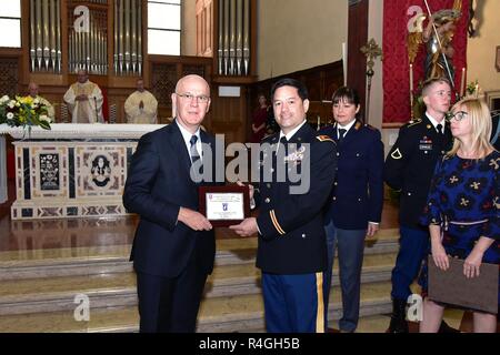 De gauche à droite, le Dr Giuseppe Petronzi Vicenza, chef de police et le lieutenant-colonel de l'armée américaine Edward Twaddel, commandant adjoint de la 173e Brigade aéroportée, l'échange de cadeaux lors de la fête de Saint Michel, à l'église de Santa Maria dei Servi à Vicenza, en Italie, le 28 septembre 2018. Saint Michel est le patron pour les parachutistes et les forces d'application de la loi italienne. Banque D'Images