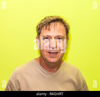Smiling man with mur jaune Banque D'Images