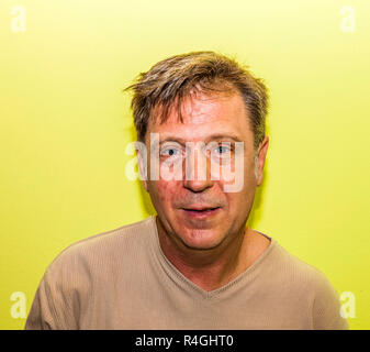 Smiling man with mur jaune Banque D'Images