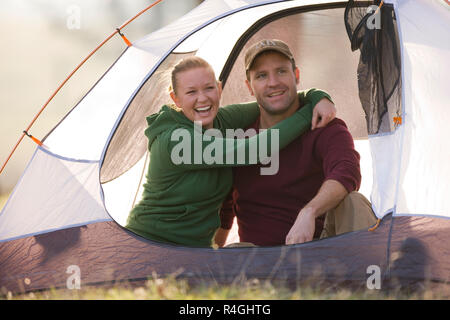 Happy young couple assis dans une tente Banque D'Images