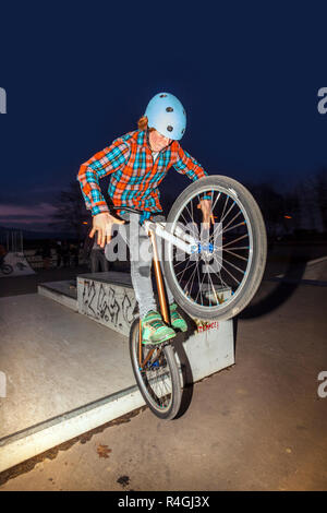 Les sauts avec son garçon dirtbike dans le skate park sur une rampe Banque D'Images