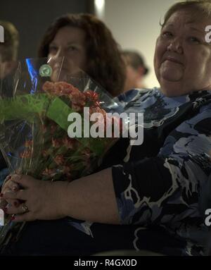 Valerie Morris, mère de l'Adjudant-chef 3 Kenneth Morris de Mahomet, l'Illinois, est titulaire d'flowers présentées par son fils dans le cadre de la cérémonie de la retraite le 6 mai 2017 au Musée militaire de l'Etat de l'Illinois à Springfield, Illinois. Morris a pris sa retraite de la Garde nationale de l'Illinois avec plus de 30 ans de service, y compris un tour de combat en Afghanistan de 2008 à 2009 avec la Garde nationale de l'Illinois à la 33e Brigade d'infanterie de l'équipe de combat. Banque D'Images