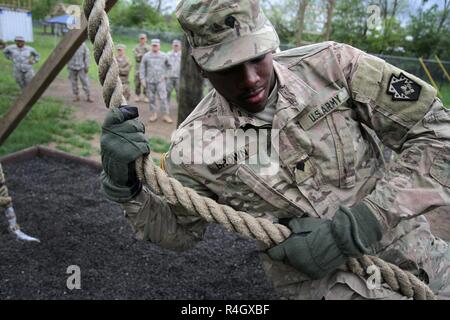 Les soldats de la 213e compagnie du personnel, 728th Bataillon de soutien au maintien en puissance de combat, 213e groupe d'appui régional de terminer une course d'obstacles le 7 mai 2017 à Fort Indiantown Gap. La CPS. Darius Brown lui-même au moyen d'une corde manoeuvres obstacle qui teste chaque haut du corps du soldat de la force et de l'équilibre. Banque D'Images