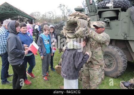 Des soldats américains de Battle Group Pologne aider les enfants mis sur l'armure de combat au cours d'une exposition statique dans le cadre de la Journée du drapeau polonais à Gizycko, Pologne 2 mai. Pologne Groupe bataille soldats ont participé à plusieurs événements sur le thème patriotique à Gizycko et 1-3 mai 2017 Orzysz, pour célébrer la saison de vacances Majówka. Banque D'Images
