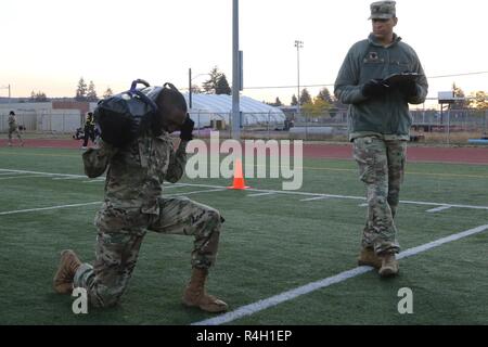 Le Sgt. 1re classe Enrique Washington, un sous-officier des opérations avec la 42e Brigade de police militaire, la 1ère Le lieutenant Arthur Dean sur les squats pondérées au cours de la partie de l'aptitude physique du soldat de la brigade trimestre concurrence sur Joint Base Lewis-McChord, dans l'état Banque D'Images