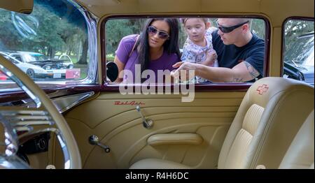 Technicien électricien de l'aviation de la Marine américaine 2e classe Pat Heffner, Centre de formation technique de l'Aviation Navale de Keesler unité instructeur, son épouse, Heather, et de sa fille, Juliana, regardez une 1957 Chevrolet Bel Air au cours de la 15e édition annuelle de Keesler Cruisin' Car Show à Marina Park à la base aérienne de Keesler, Mississippi, le 29 septembre, 2018. L'événement est organisé pour donner le coup d'Cruisin' de la côte, un festival pour célébrer les camions et voitures classiques, hot rods, où les véhicules croisière le long du bord de l'autoroute 30-mile au Mississippi. L'événement a accueilli les visiteurs, les véhicules classiques et présenté plusieurs présentation de prix Banque D'Images