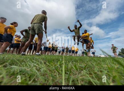 Les soldats, marins, aviateurs et marines se relaient sautant par-dessus une corde pendant le Défi de remise en forme mixte d'Okinawa, le 26 septembre 2018, à Kadena Air Base, au Japon. Corde à sauter le défi exige de tous les 48 élèves à saute sur la corde s'il est en mouvement. Si la corde a touché un étudiant alors qu'ils sautaient dessus, ou si la corde est arrêté, les élèves devraient commencer plus d'encore. Banque D'Images