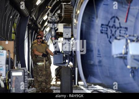 Navigant de première classe Thomas Kervian, 41e Unité de maintenance d'hélicoptères HH-60G Pave Hawk, chef de l'équipe de guides un hélicoptère à être attachés dans un C-5 Galaxy avant un déploiement, le 26 septembre 2018, à Moody Air Force Base, Ga, la 41e et la 41e QR Unité de maintenance hélicoptère fournira des capacités de recherche et de sauvetage de combat et des opérations d'entretien dans un emplacement déployées à l'avant. Banque D'Images