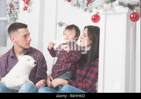 Père avec ours en peluche peluche Mère avec enfant mignon sur le porche de l'hiver maison de Noël Banque D'Images