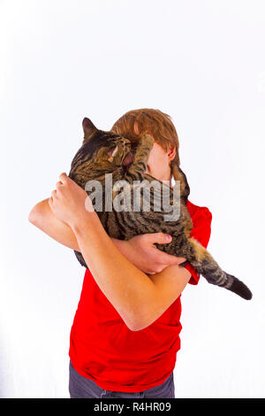 Cute boy hugging son chat Banque D'Images