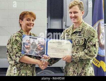 PENSACOLA, Floride (sept. 25, 2018) - Le Cmdr. Malissa 2000-08, gauche, annonce l'Hospital Corpsman 2e classe Scott Barder comme l'honneur diplômé du cours d'assistant médical de vol (FMC) à l'Institut médical de l'Aéronautique Navale (NAMI). FMC enseigne aux étudiants les fondements de la traumatologie pédiatrique, l'éducation pour les professionnels de soins préhospitaliers et advanced life support cardiovasculaire classes. Banque D'Images