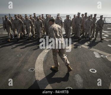 La mer d'OMAN - U.S. Marine Cpl. Diego Carroll, ingénieur de combat avec la compagnie Kilo, bataillon de l'équipe d'atterrissage 3/1, 13e Marine Expeditionary Unit (MEU), ouvre les rangs d'une formation en cours de caporal à bord de la classe Whidbey Island landing ship dock USS Rushmore (LSD 47), 25 septembre 2018. Le groupe amphibie d'Essex et 13e MEU sont déployés dans le domaine de la 5e flotte américaine des opérations à l'appui des opérations navales pour assurer la stabilité et la sécurité maritime dans la région Centrale, reliant la Méditerranée et le Pacifique à travers l'ouest de l'Océan indien et trois points d'étranglement stratégiques Banque D'Images