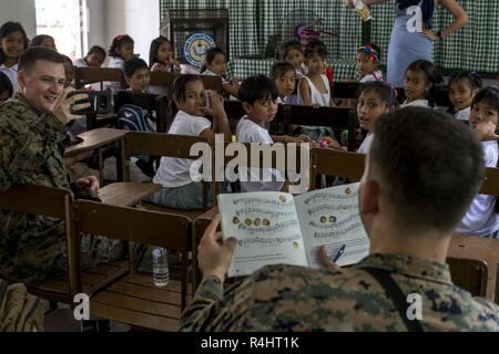 U.S. Marine Corps Capt Mark Hanford mène une chanson lors de l'exercice KAMANDAG 2 à Ternate, Cavite, Philippines, Oct 3, 2018. KAMANDAG 2 est un exercice d'entraînement de routine qui permet aux Marines américains pour soutenir l'intérêt humanitaire de nos partenaires philippins. Hanford, Daytona Beach, Fl., est un Civil Affairs attribué à III Marine Expeditionary Force l'élément de commande. Banque D'Images