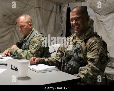 Le colonel de l'armée américaine Jason E. Briggs, à gauche, et le Sgt Commande. Le Refugio Rosas sont informés par les membres du personnel de soutien de la 224e Brigade, la Garde nationale de Californie, dans le centre d'opérations tactiques au Camp Atterbury, Indiana, Octobre 1, 2018. La 224e SB sont arrivés au Camp Atterbury en septembre 2018 pour participer à Warfighter 19-1. Banque D'Images