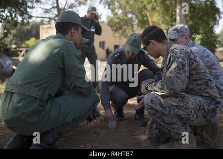 Un U.S. Marine conseille aux membres des Forces armées royales marocaines sur la façon de traiter les dangers d'explosion simulée au cours de l'action humanitaire antimines formation niveau 2 à unir de secours et sauvetage, de base de Kénitra, Maroc, Septembre 26, 2018. HMA niveau deux est le deuxième niveau de l'HMA exchange dans lequel des partenaires étrangers se réunissent pour former aux côtés des Marines américains et des soldats dans le but d'apprendre à atténuer les dangers d'explosion. C'est la première fois que le niveau d'enrobage à deux ont été menées sur le continent de l'Afrique. Banque D'Images