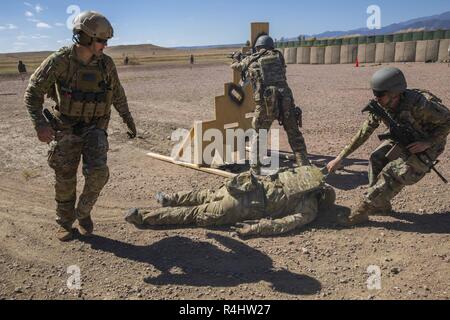 Un Béret Vert de l'armée américaine, soldat affecté à 10e Groupe des forces spéciales (Airborne), crie instructions comme un catalyseur essentiel fait glisser une victime simulée lors d'un shoot de stress à Fort Carson, Colorado, le 28 septembre 2018. La formation à l'honneur leur préparation pour les futurs déploiements et leur volonté de lutte dans l'instant. Banque D'Images