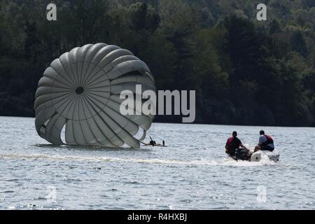 Les membres de la Virginie de l'Ouest Sauvetage en eau Plateau (WVSWRT) vitesse sur le lac Beech pour hisser à un soldat du 2e Bataillon, 19e Groupe des forces spéciales (Airborne) 21 septembre 2018 à Huntington, W.Va. Le 2/19ème ligne statique rempli de soldats pour maintenir leurs compétences de formation en parachutisme dans les opérations aéroportées. Banque D'Images