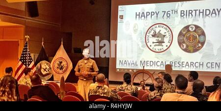 Le Capitaine Adam, Commandant Armstrong, Naval Medical Research Centre (NMRC), parle au personnel au cours de la 76e célébration anniversaire NMRC. Banque D'Images