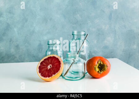 Verre vide bouteilles recyclées pour le petit déjeuner, jus de fruits frais et d'autres besoins dans la cuisine. verrerie sur tableau blanc et bleu fond Banque D'Images