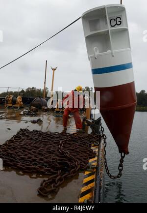 Maître de 2e classe Trevor Tyler, un officier à bord de l'manœuvriers garde-voyages Bluebell la capture sur un arrêt de la chaîne d'abandonner la chaîne d'une bouée d'amarrage dans l'eau à Tongue Point, à Astoria, Oregon, le 30 octobre 2018. Pour des raisons de sécurité, le reste de l'équipage s'effacer quand la chaîne est libéré sur le côté du Bluebells gunnel. Banque D'Images