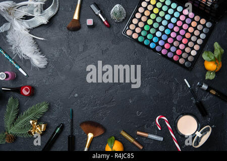 Photo d'arbre de Noël, mandarin, pinceaux, palette de rouge à lèvres, avec ombres sur le tableau noir Banque D'Images
