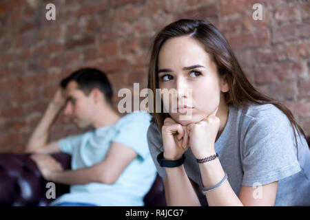 Offensé l'homme et la femme sont assis séparément sur un canapé. Banque D'Images