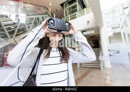 Femme regardant si VR appareil dans shopping mall Banque D'Images