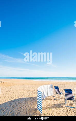 Chaises bleu et blanc et à l'abri du vent plage déserte, Praia Grande, armacao de pera, Algarve, PORTUGAL Banque D'Images