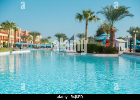 Luxe magnifique parasol et chaise autour d'une piscine extérieure dans l'Hôtel et resort avec coconut palm tree on blue sky - Booster Le traitement de la couleur. Banque D'Images