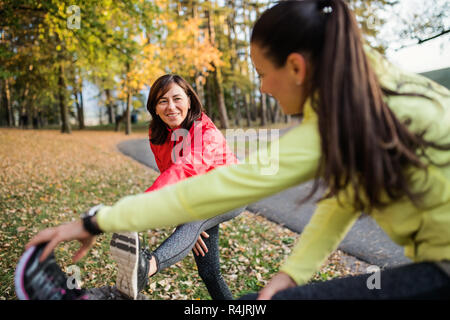 Deux dames s'étend les jambes à l'extérieur dans le parc en automne la nature. Banque D'Images