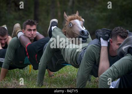 Les Marines américains affectés à basse altitude 2D de défense aérienne de l'équipe du bataillon 'One' effectuer squad push-ups au cours de l'unité tout-terrain sur la concurrence Marine Corps Air Station Cherry Point, en Caroline du Nord, le 26 octobre 2018. L'ATUC est un événement annuel organisé par Cherry Point Marine Corps Services communautaires pour les Marines et les marins sur la station d'établir de bons grâce à des compétitions amicales. Les membres de service devaient faire face à de multiples défis physiques et mentaux tout au long d'un cours de six milles, y compris d'être pourchassé par les bénévoles agissant comme des zombies, fournie par le programme marin unique. Si un concurrent a e Banque D'Images