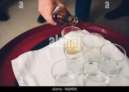 Barman pouring boissons digestif dans les verres au bar. Banque D'Images