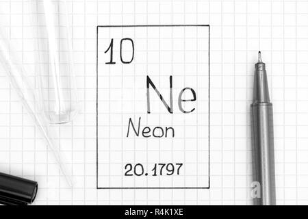 Le tableau périodique des éléments. L'élément chimique de l'écriture manuscrite ne Néon avec un stylo noir, tube à essai et pipette. Close-up. Banque D'Images