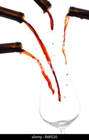 Vin rouge versé par beaucoup de bouteille dans un verre de vin vide Banque D'Images