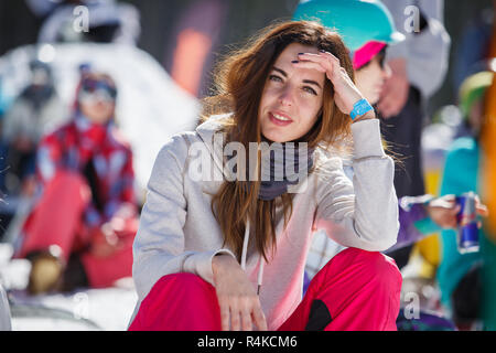 BUKOVEL,UKRAINE-19 mars,2018 : Portrait of pretty brunette rider girl sitting on voie prêt à rouler.Winter festival de sports d'action in snow park.Les Jeunes Banque D'Images