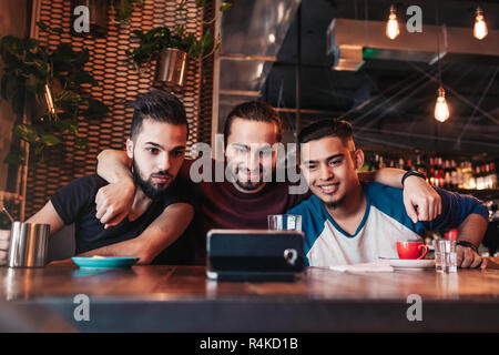 Groupe d'amis arabes prenant en selfies bar-salon. Mixed Race jeunes hommes ayant in loft cafe Banque D'Images