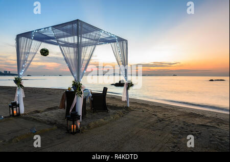 Dîner romantique sur la plage au coucher du soleil de configuration Banque D'Images