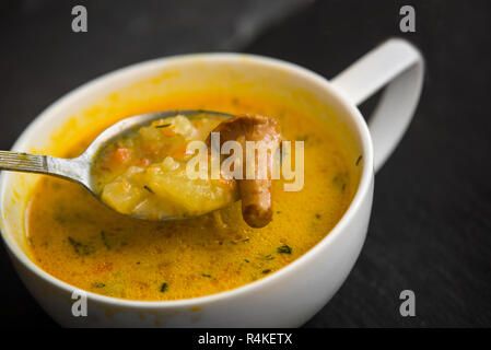 Soupe à la crème aux champignons girolles et herbes pierre noire background Banque D'Images