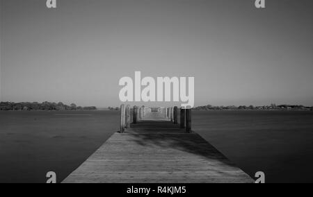 Un quai vide se trouve sur l'eau calme sous un ciel bleu Banque D'Images