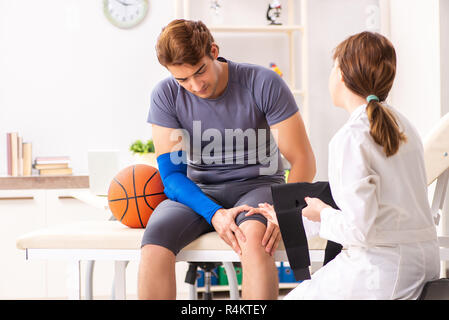 Beau joueur de basket-ball féminin en visite médecin traumatologist Banque D'Images