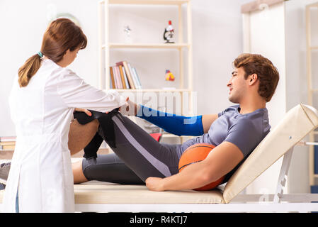 Beau joueur de basket-ball féminin en visite médecin traumatologist Banque D'Images