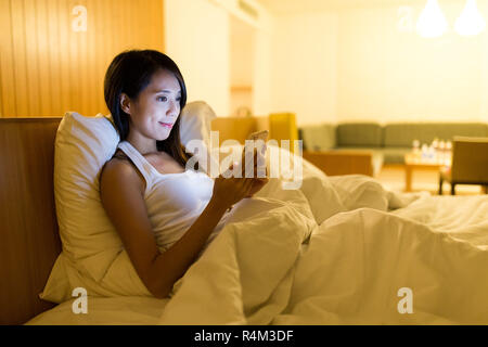 Woman using mobile phone in home Banque D'Images