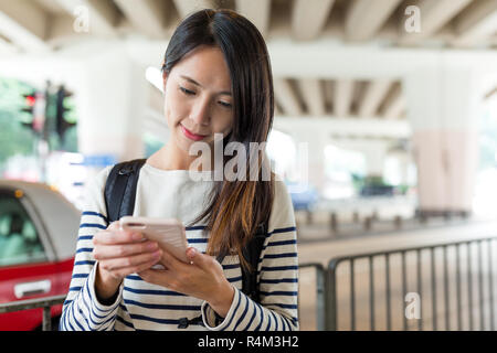 Woman checking sur smartphone at outdoor Banque D'Images